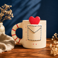 Handpainted ceramic mug with 3D heart topper and envelope pocket design
