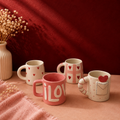 Assorted set of four heart-themed ceramic mugs — scattered, checkered, embossed, and envelope designs
