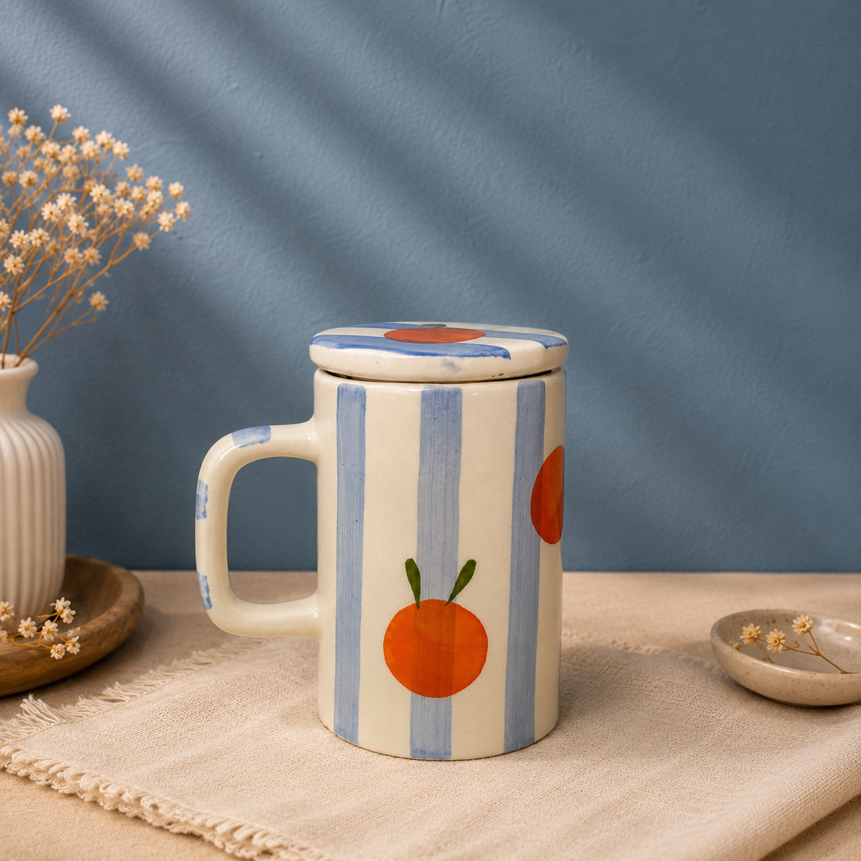 handmade blue striped ceramic mug with orange fruit print and lid