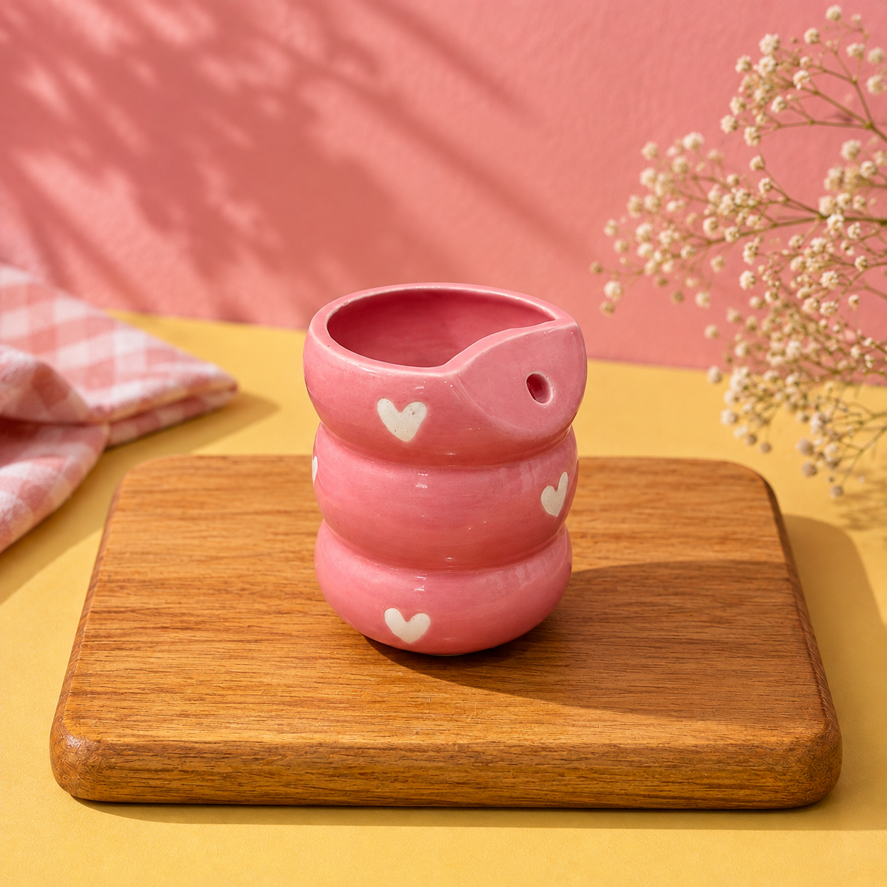 Handmade pink ceramic tumbler with white hearts and chunky bubble texture